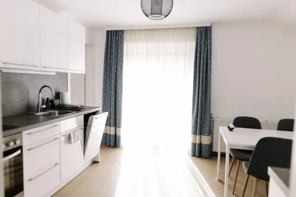 Világos étkezőasztal sötét székekkel és kék mintás függönnyel