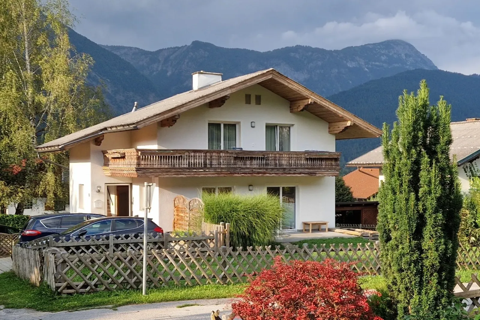 Alpesi stílusú apartmanház külső nézete hegyekkel a háttérben