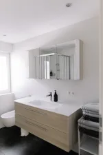 Modern fürdőszobai mosdó nagy tükrös szekrénnyel és törölközőkkel